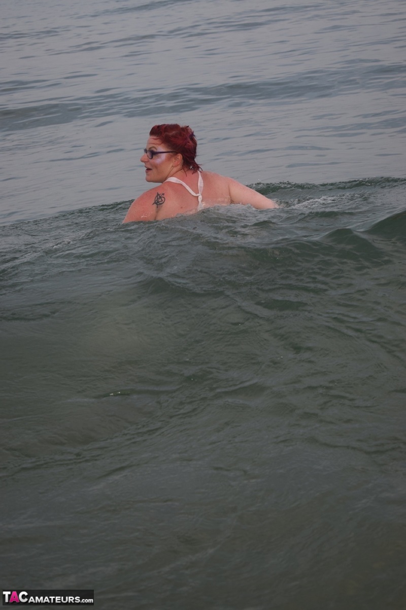 Tattooed redhead poses nude on a beach before masturbating on a toilet seat  