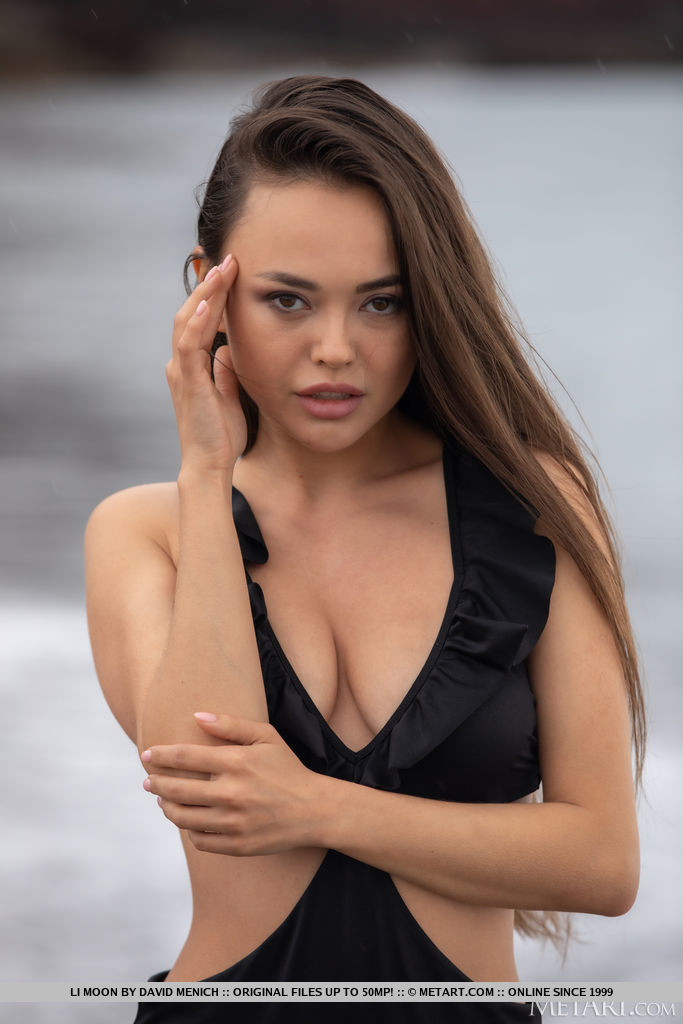 Young beauty Li Moon removes black swimwear to go naked on a beach
