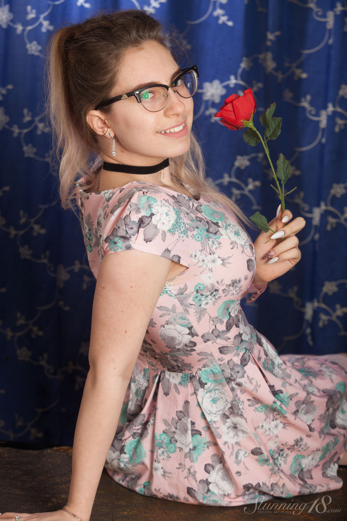 Nerdy 18 year old Liza Loo holds a rose showing her firm breasts in glasses